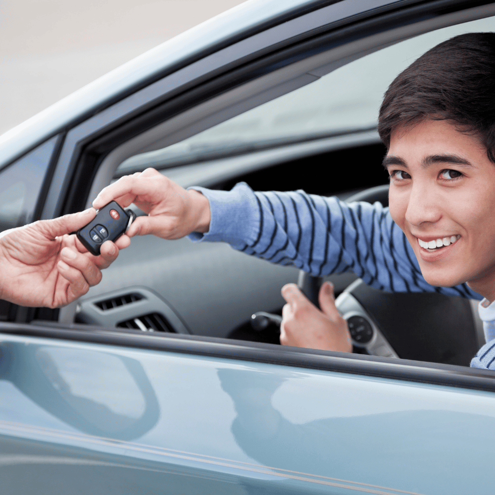 Happy student receiving car keys after a driving lesson with Zack Driving School